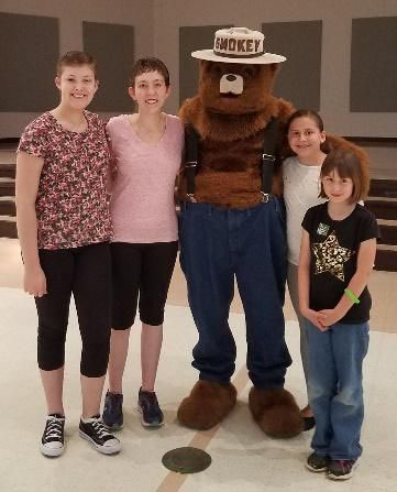 Two kids and two women with a mascot