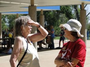 Two women talking with people behind