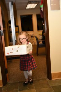 A child carrying a box